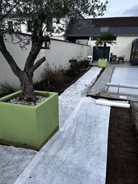 Pose d'une protection géotextile au sol avant la pose d'une pelouse synthétique à Saint-Cyr-sur-Loire près de Loches