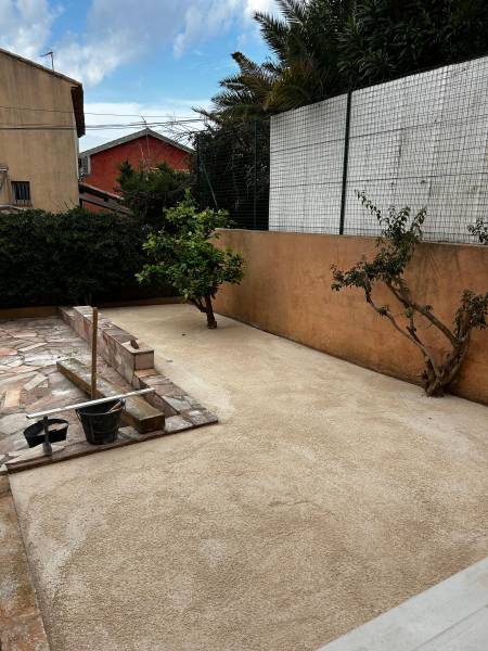 Réalisation d'un lit de sable avant la pose d'une pelouse synthétique