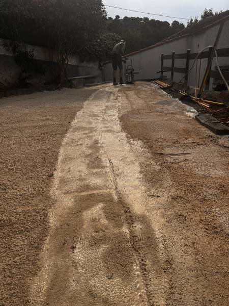 Pose d'un lit de sable sur géotextile pour l'installation d'une pelouse synthétique